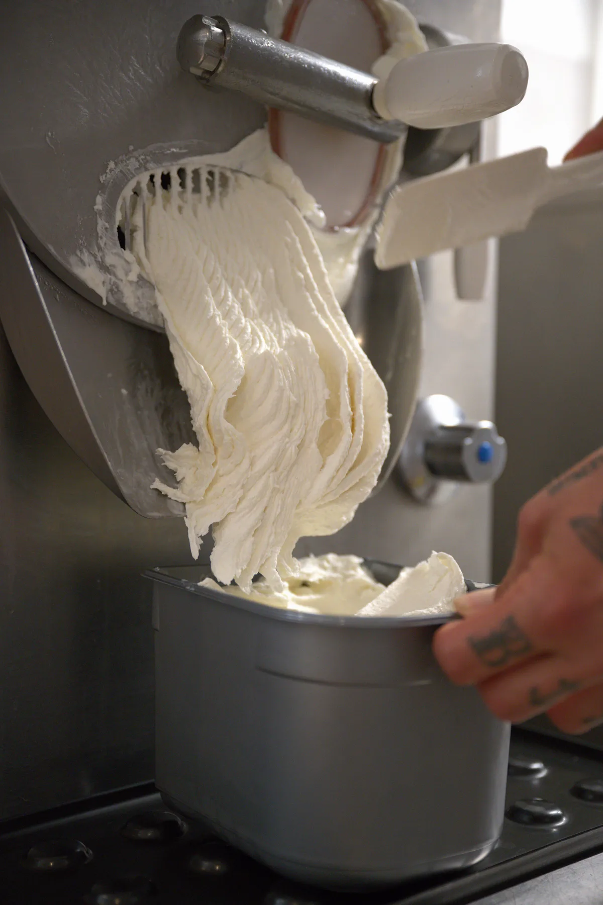 … und schon kommt aus der Maschine ein Fior di Latte. Glace kommt aus einer Maschine heraus.